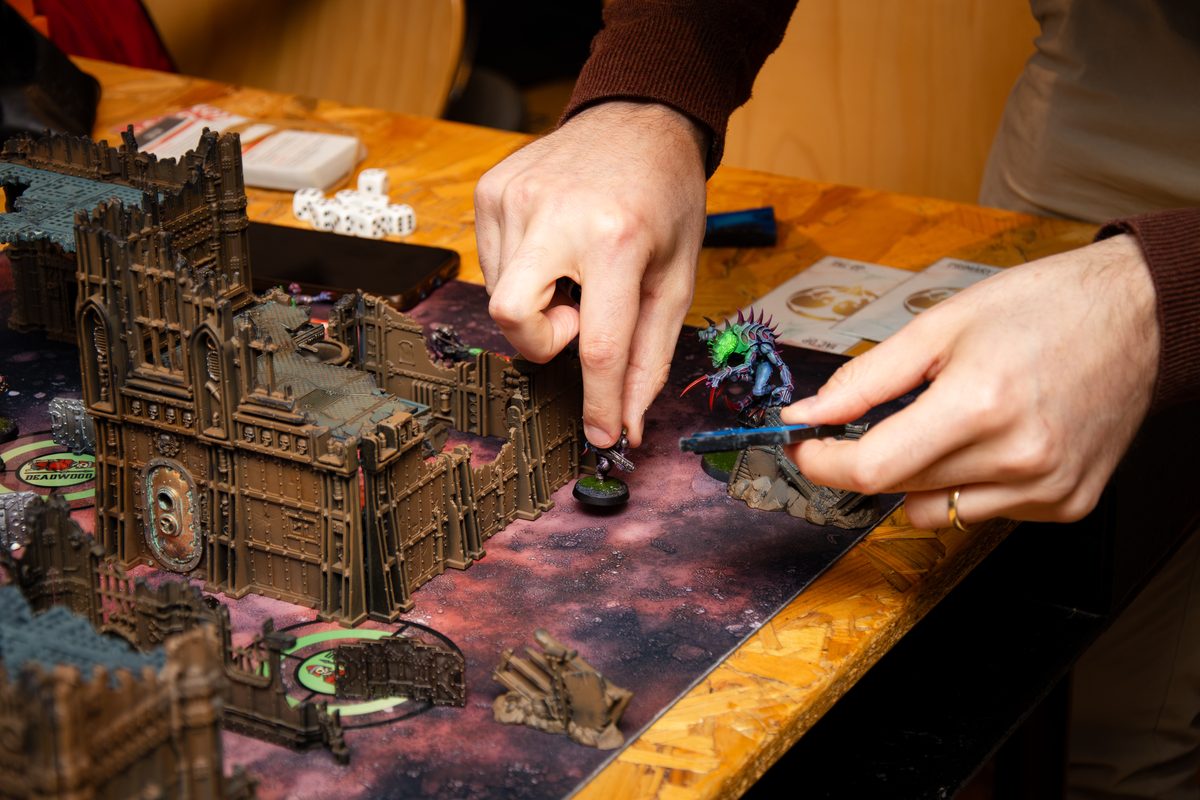 A wargaming battle in progress on the terrain tables at Board & Brewed