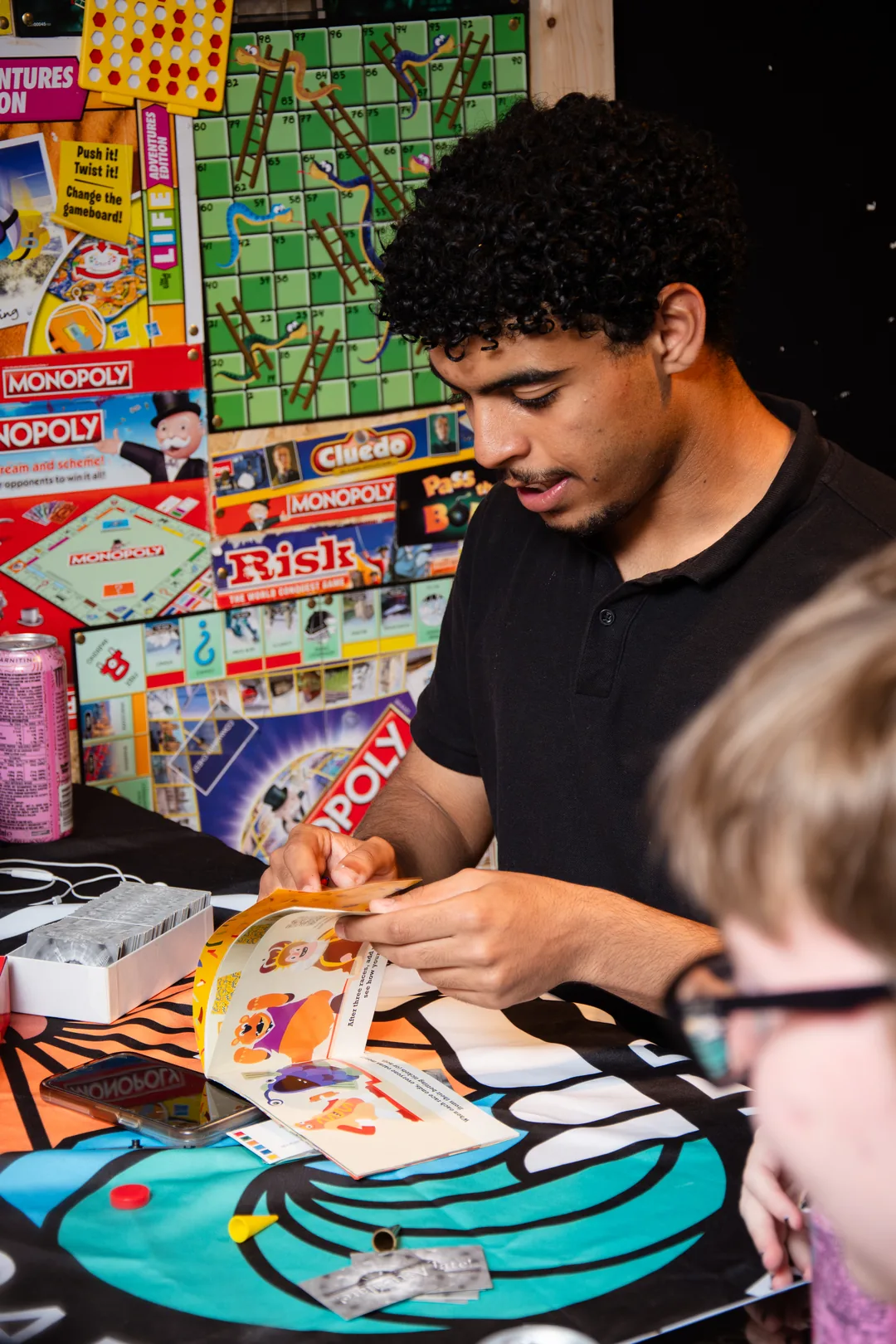 A player mid-game in front of the board game wall at Board & Brewed