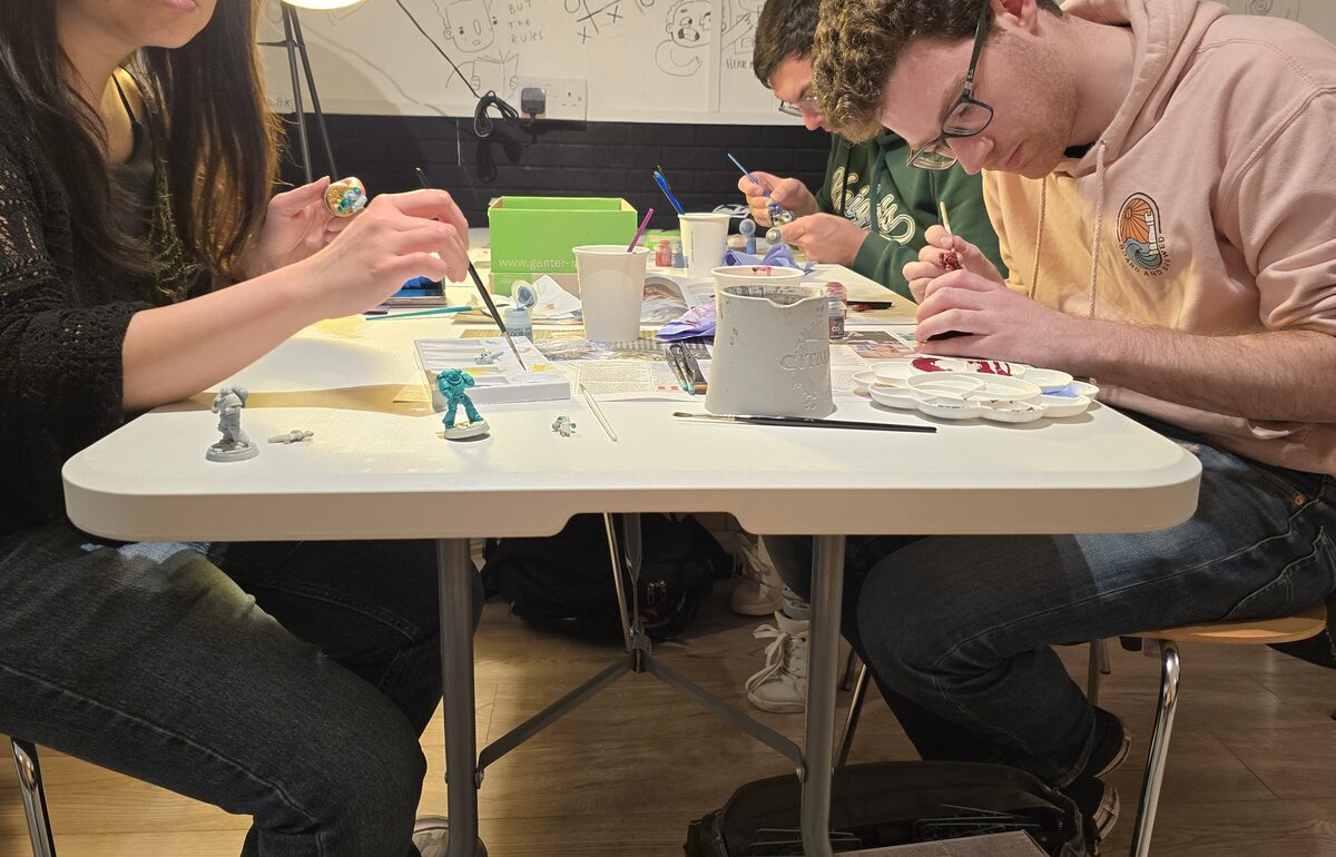 Customers painting miniatures at a Board & Brewed community event