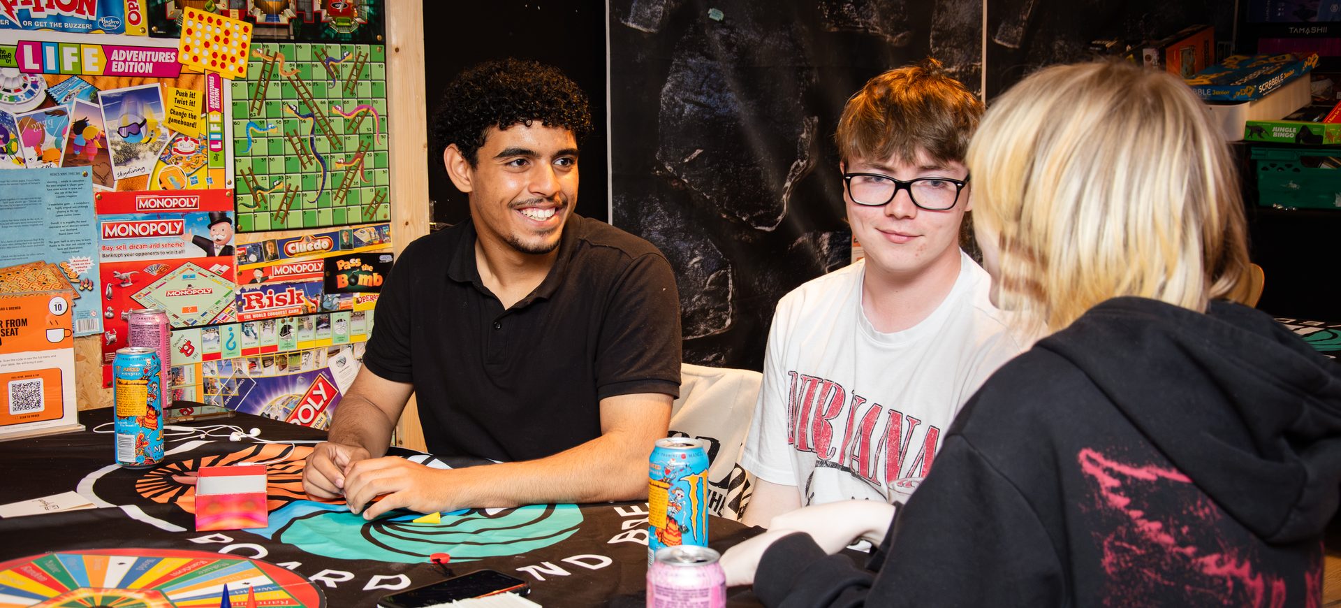 Friends laughing over a board game at Board & Brewed